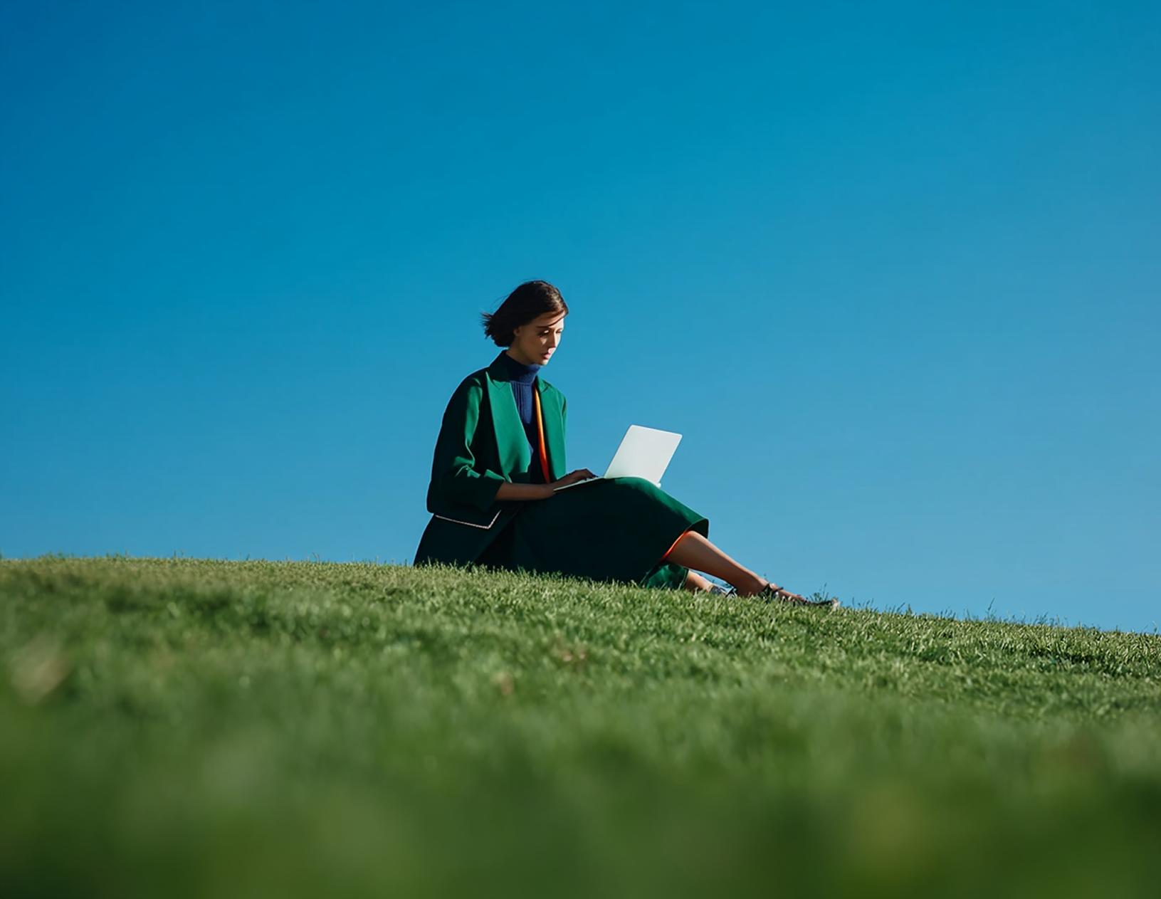 Persona editando su sitio WordPress con su laptop en un campo abierto